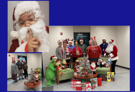 Group of staff in front of Christmas decorations with Christmas hats and headbands on with one dressed as Santa