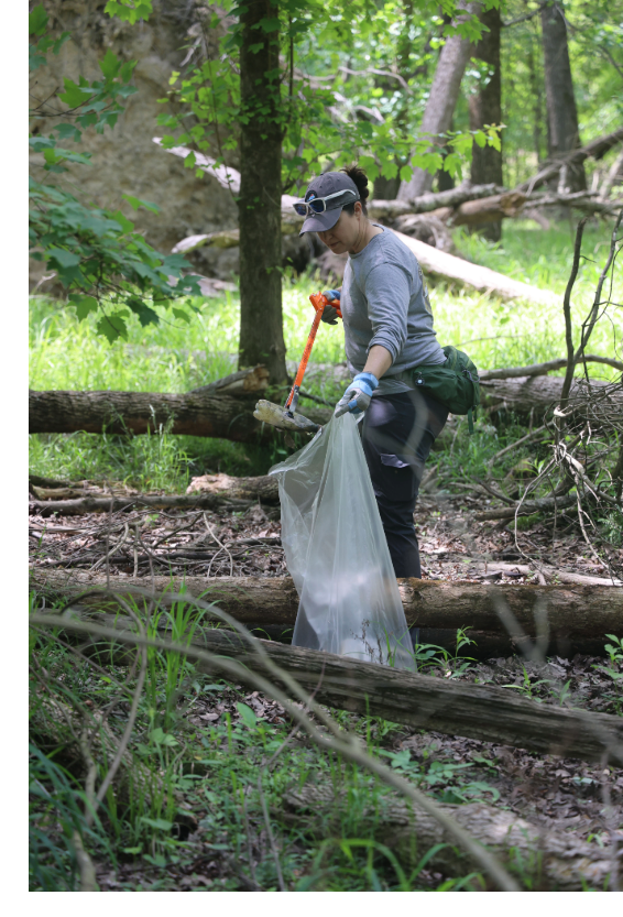 DEQ staff member picking up plastic trash
