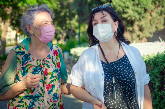 Two hispanic women talking with masks