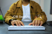 Stock photo of man typing on keyboard with superimposed text reading "JOB SEARCH"
