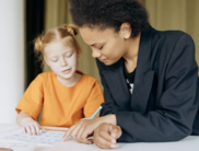 Adult assists child with writing