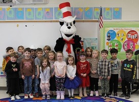 18 young elementary students in a classroom with Cat in the Hat.