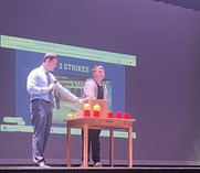 Game host and student participant playing the Price is Right on stage.
