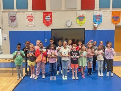 A large group of young students holding library cards