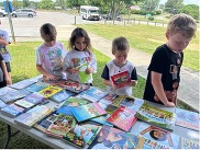 Young students choosing books from a table