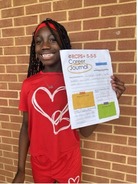 A smiling student holding up a career journal