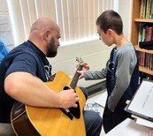 School counselor playing guitar for a student