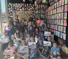 A group of students surrounded by colorful artwork