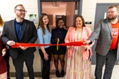 Teachers cutting a ribbon in front of the new wellness room