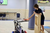 A student in a robotics competition with a machine