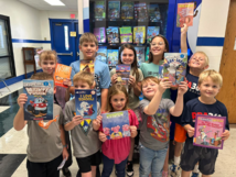 Students holding up books