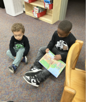 An older and younger student reading together