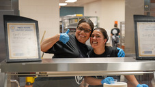 Two smiling staff members in a cafeteria