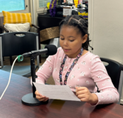 A student speaking into a podcast microphone