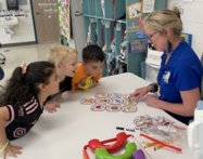 A teacher teaching students literacy with cards