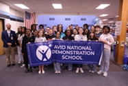 Indian River Middle School faculty and students holding an AVID banner