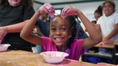 Young student making pink oobleck