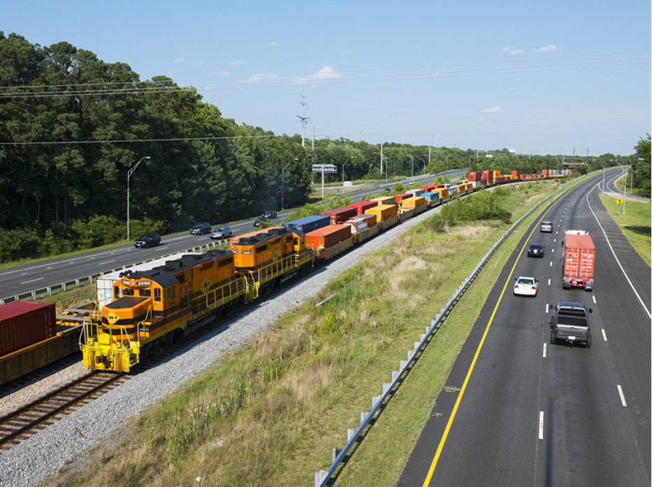 freight train and cars on highway