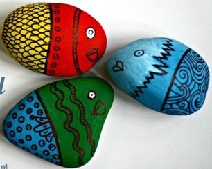 Three rocks painted like fish in various patterns and colors