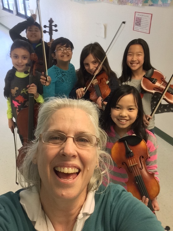 photo of students with violins and adult