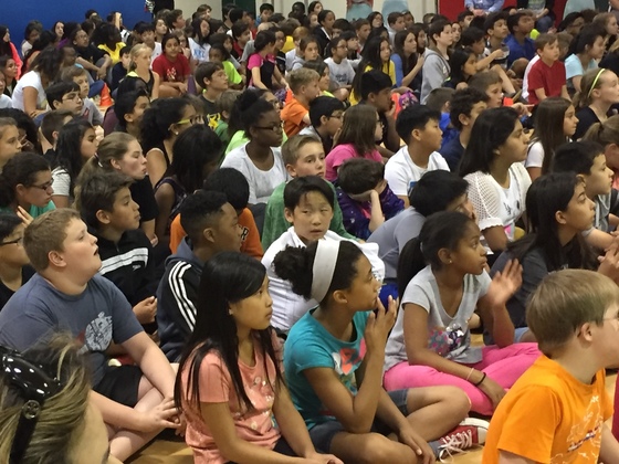 photo of many students seated on floor for concert