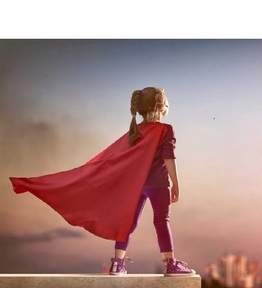 young girl with a cape looking off into the sky