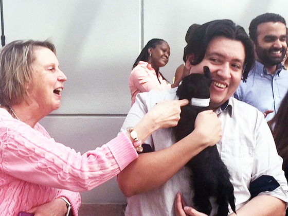 Staff member Michael Sanchez holding a puppy