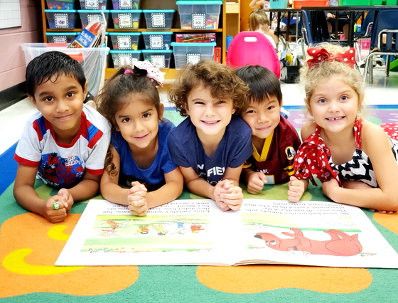 kindergarten students reading a book together