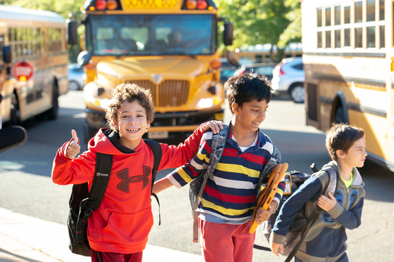 Student walking to school with thumbs up