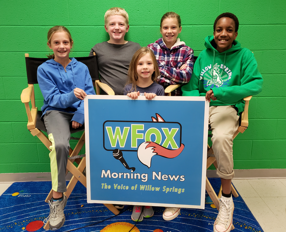 5 students with WSES Morning News Sign