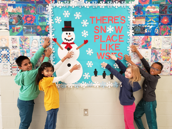 Students standing in front of snowman bulletin board