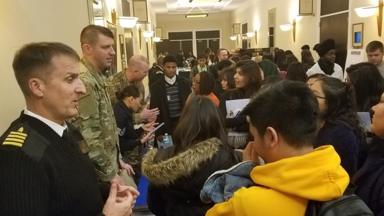 Picture of students talking to military officers