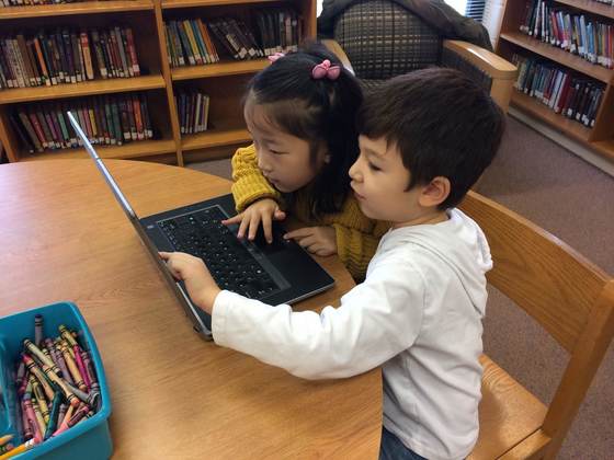 Kindergartners are working together to solve puzzles.