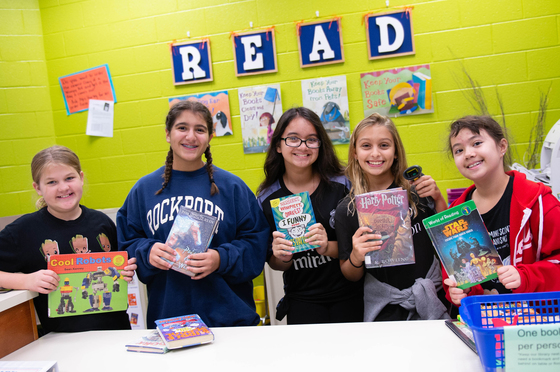 Students in library holding books