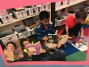 Students seated on a rug, reading in a classroom