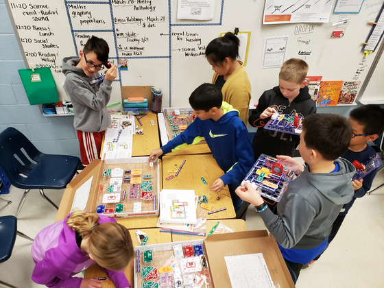 students working in classroom with snap circuits