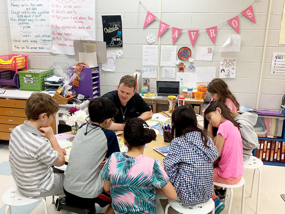 Principal Taylor working with students in classroom