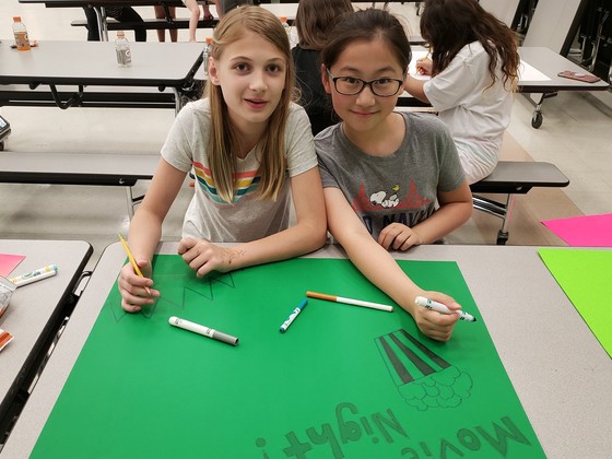 2 students creating movie night posters
