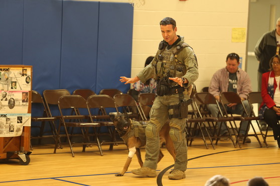 Ajax the police dog walks with his handler during a demonstration for Clermont students.