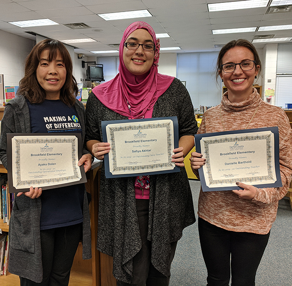 Three staff members with their awards
