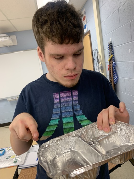 Student collecting aluminum trays