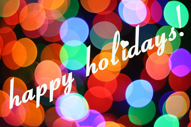 The words Happy Holidays atop multicolored dots of light. 