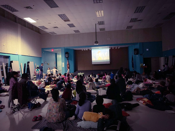 cafeteria filled with students watching a movie