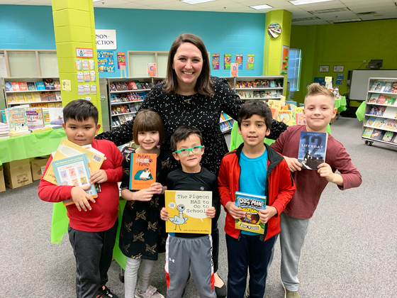 librarian with students at book fair
