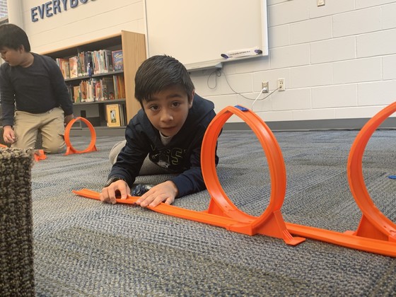photo of a student building a car track
