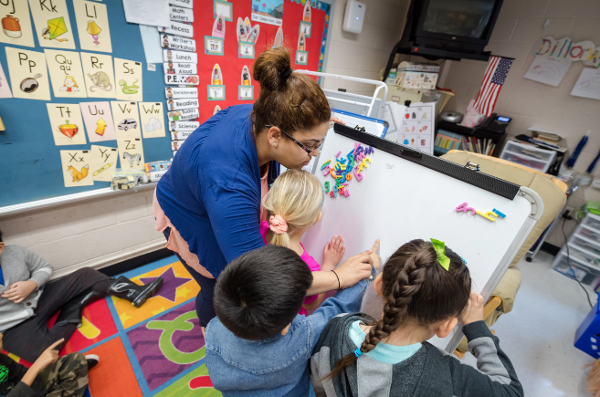 Teacher guiding students during a lesson.