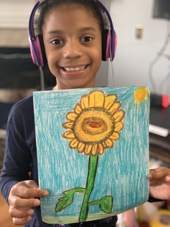 Photo of a student holding up her artwork