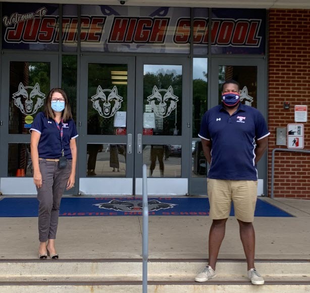 Justice HS staff wearing masks outside of the school's main entrance.