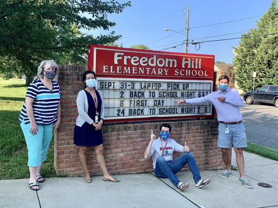 Freedom Hill ES staff in front of the school sign. 