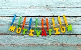 colorful letters on a string against a wood paneled background spelling out MOTIVATION